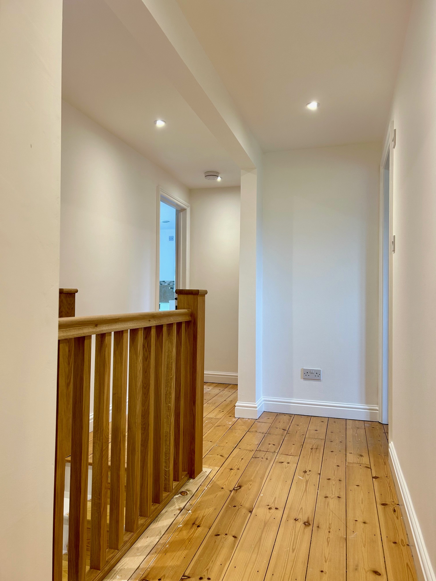 Finished upstairs hallway with oak balustrade and painted walls